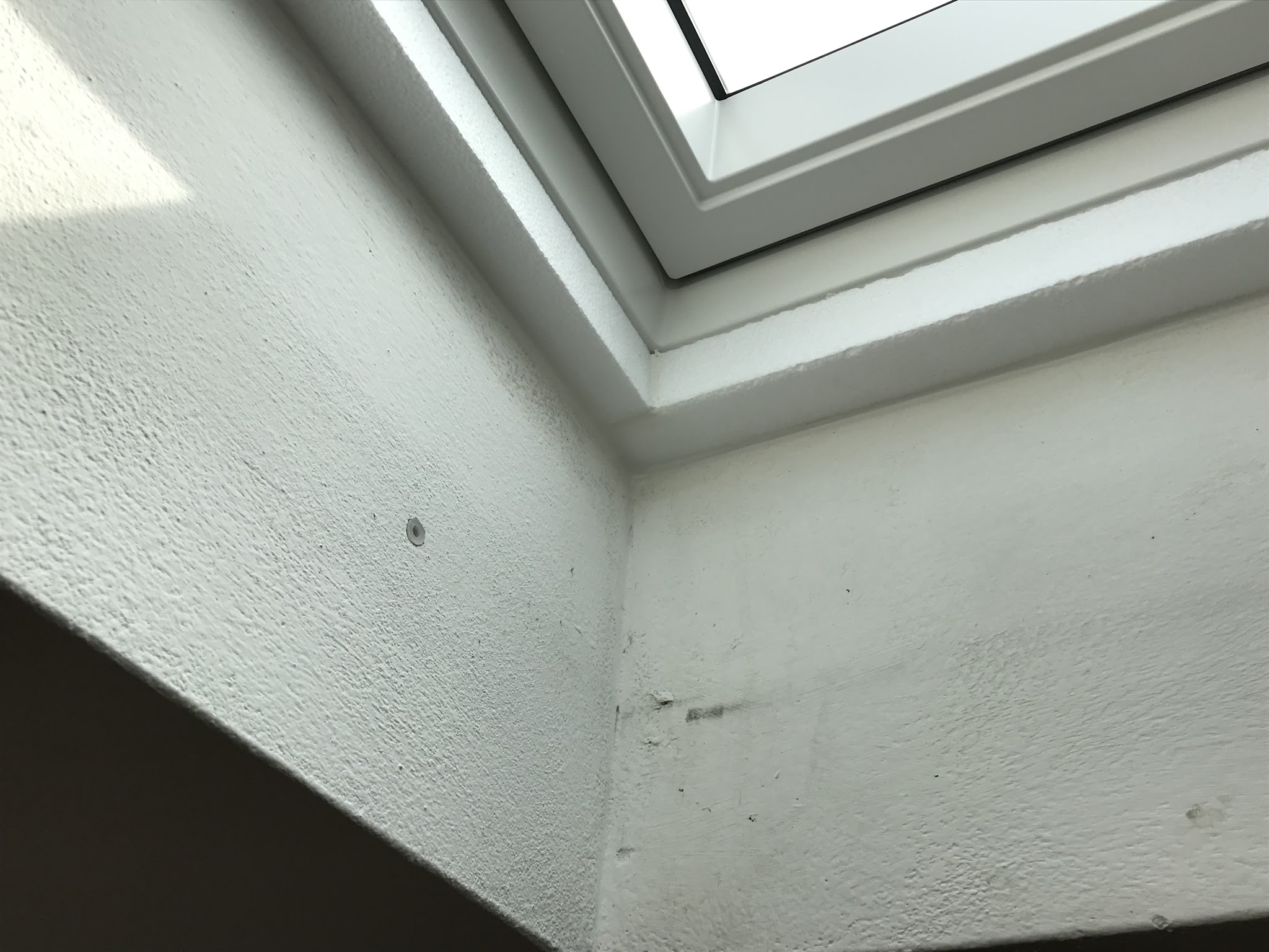 Dettaglio del contorno intonacato di una finestra per tetti